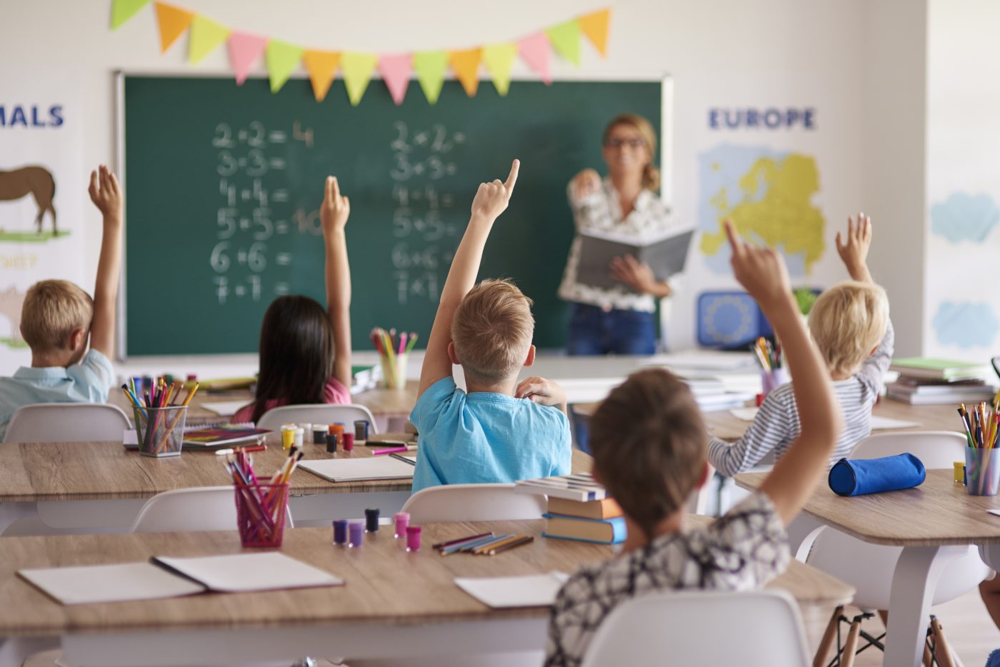 Students raising their hands to answer in class